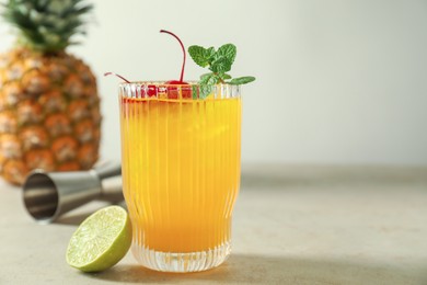 Photo of Tasty pineapple cocktail with mint and cherry in glass served on light table, space for text