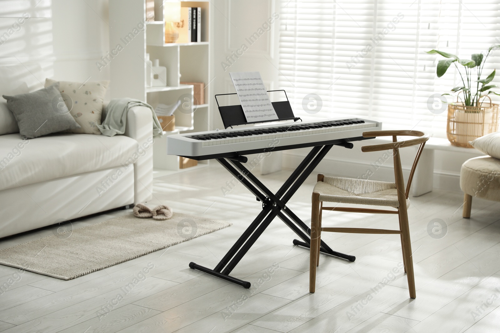 Photo of Synthesizer with music sheet and chair at home