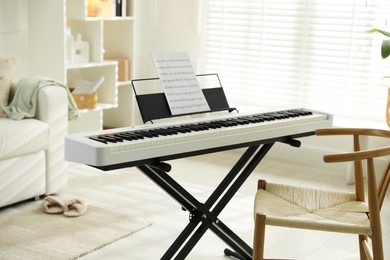 Photo of Synthesizer with music sheet and chair at home