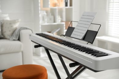 Photo of Synthesizer with music sheet at home, closeup