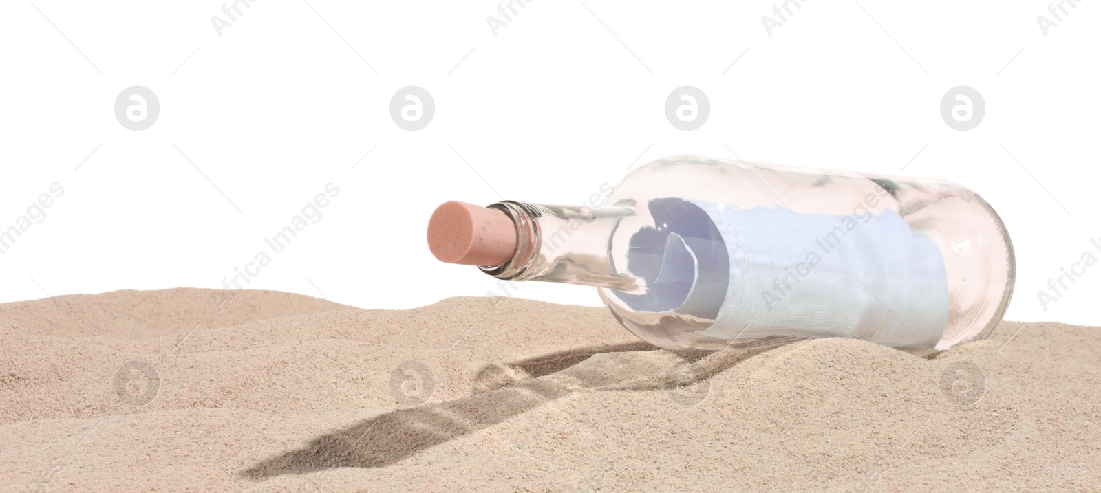 Photo of Rolled letter in corked glass bottle on sand against white background