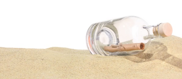 Photo of Rolled letter in corked glass bottle on sand against white background