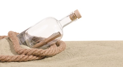 Photo of Rolled letter in corked glass bottle and rope on sand against white background