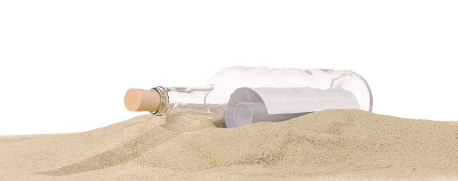 Photo of Rolled letter in corked glass bottle on sand against white background