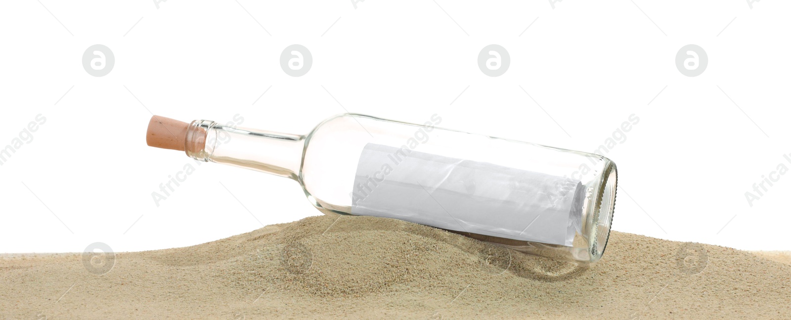 Photo of Rolled letter in corked glass bottle on sand against white background