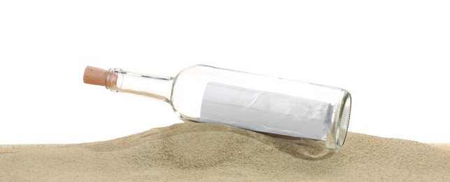 Photo of Rolled letter in corked glass bottle on sand against white background