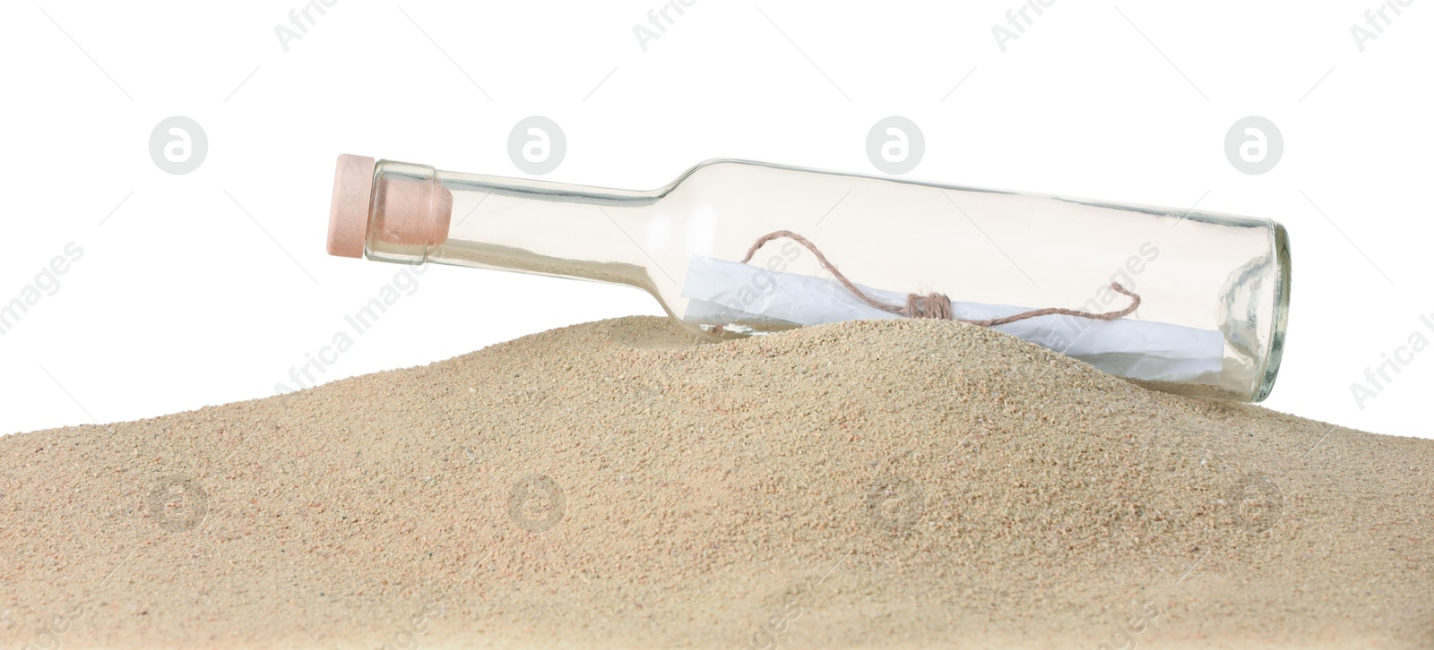 Photo of Rolled letter in corked glass bottle on sand against white background