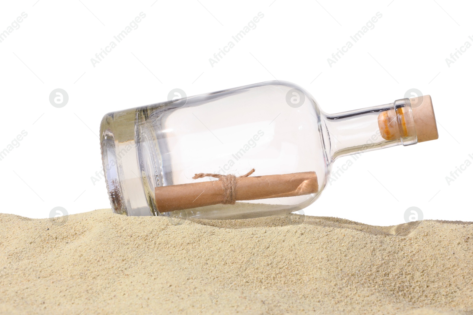 Photo of Rolled letter in corked glass bottle on sand against white background