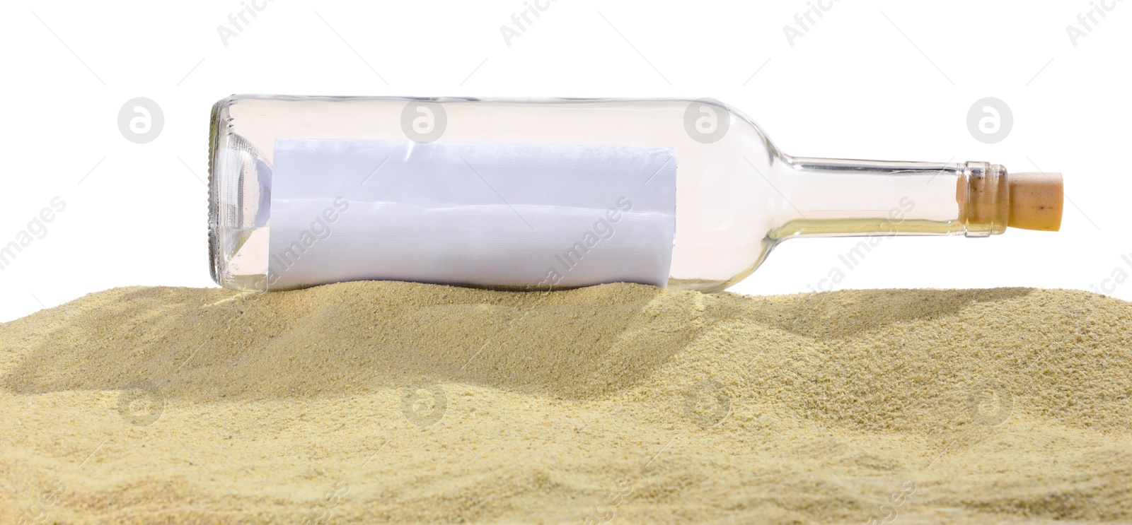 Photo of Rolled letter in corked glass bottle on sand against white background