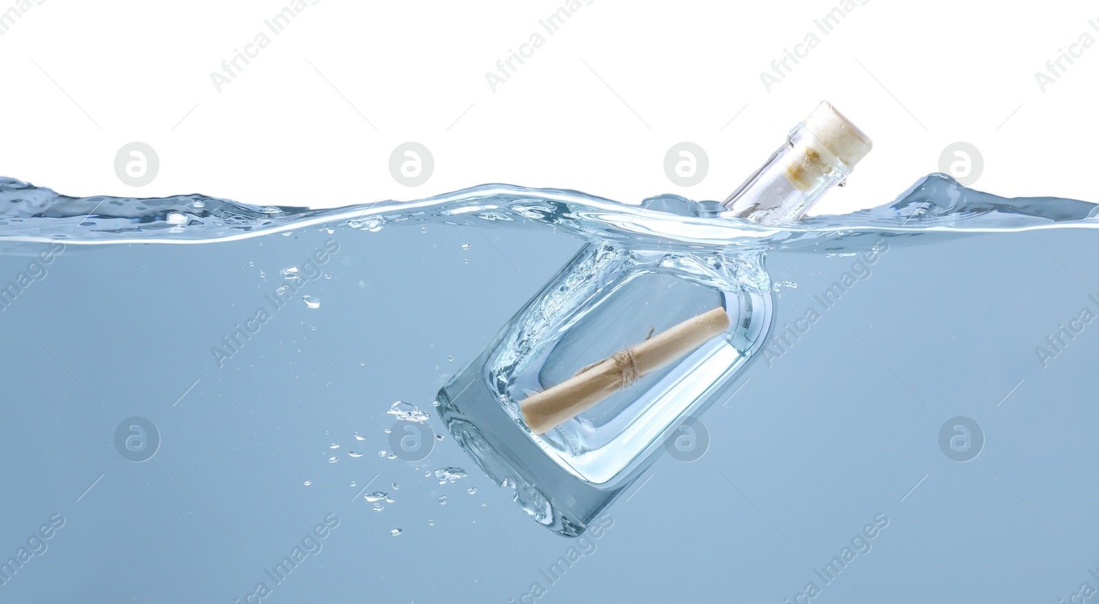 Photo of Corked glass bottle with rolled letter in water on white background