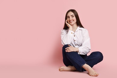 Photo of Smiling woman in stylish jeans on pink background. Space for text