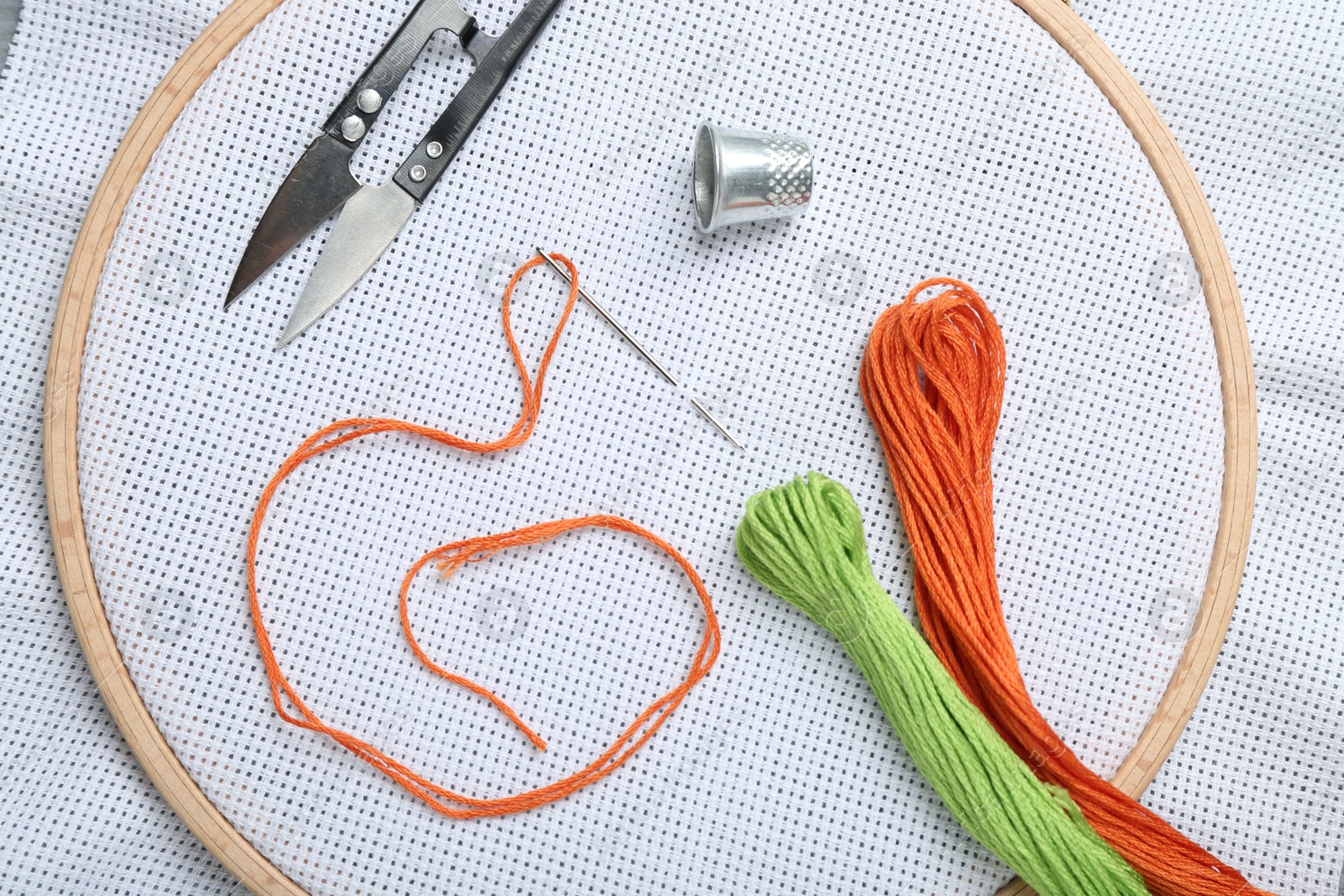 Photo of Different sewing supplies for embroidery on fabric, flat lay