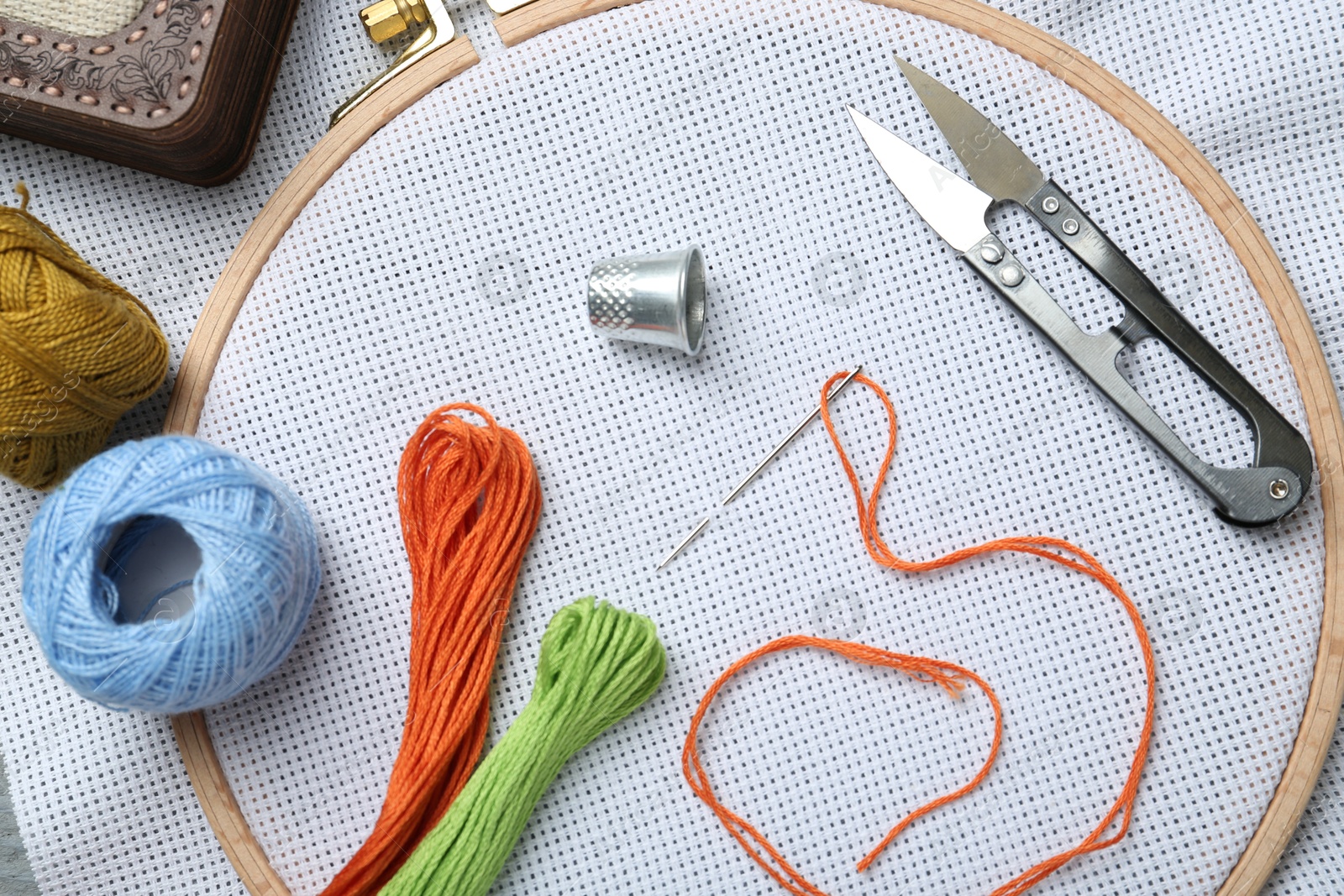 Photo of Different sewing supplies for embroidery on fabric, flat lay