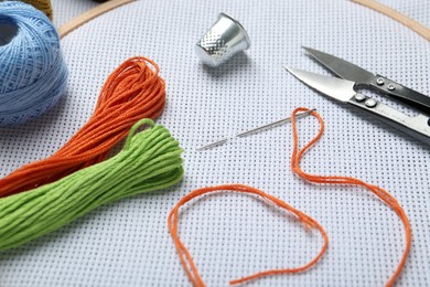 Photo of Different sewing supplies for embroidery on table, closeup