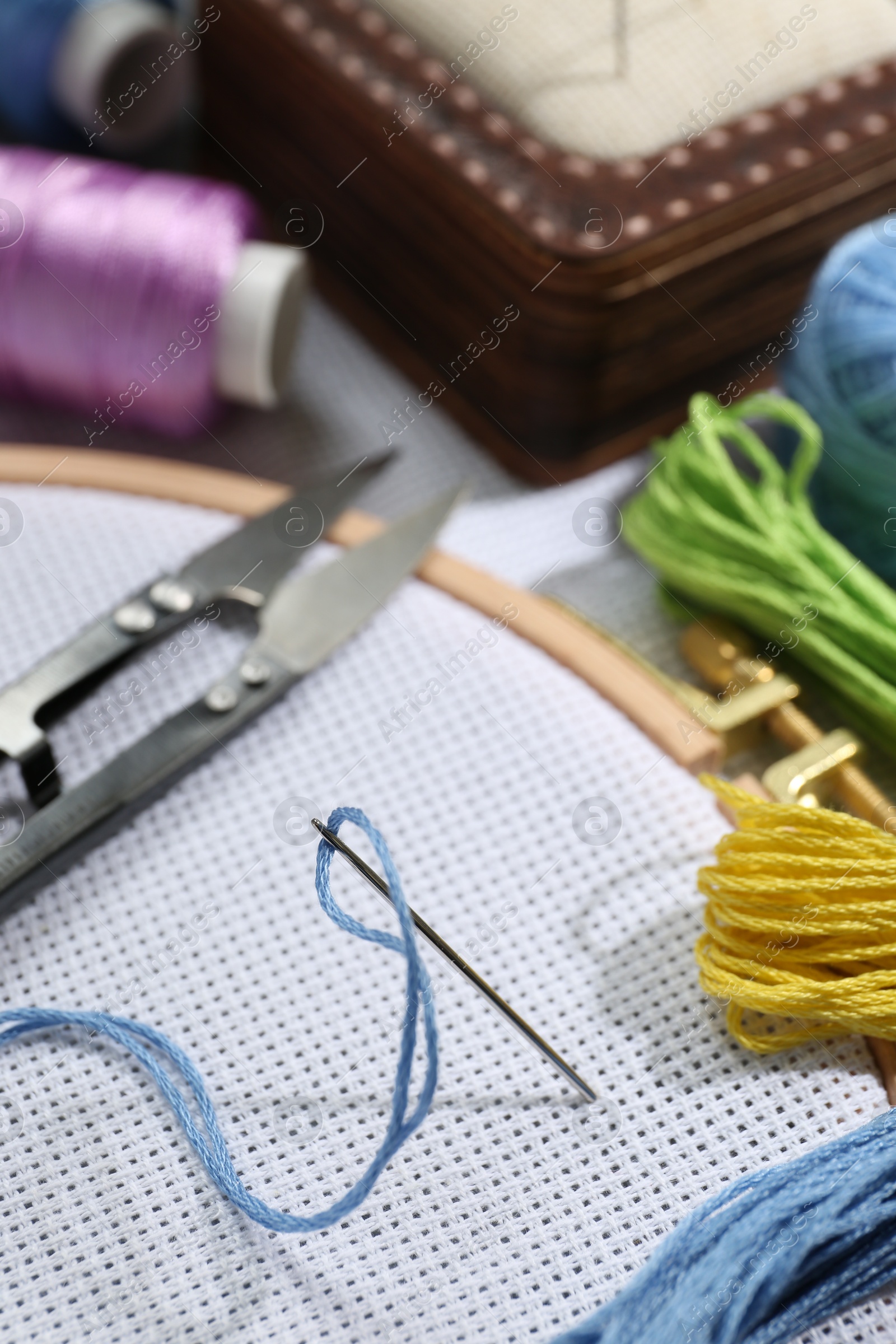 Photo of Different sewing supplies for embroidery on table, closeup