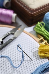 Photo of Different sewing supplies for embroidery on table, closeup