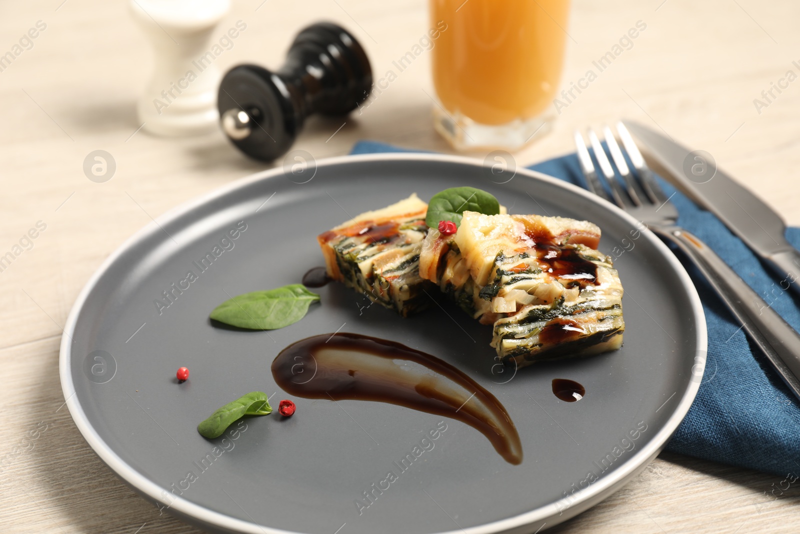 Photo of Pieces of tasty spinach lasagna on wooden table, closeup