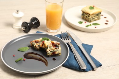 Photo of Pieces of tasty spinach lasagna served on wooden table, closeup