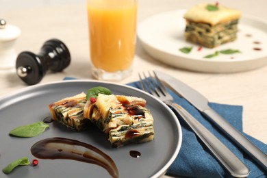 Photo of Pieces of tasty spinach lasagna served on table, closeup