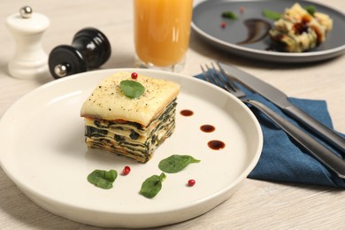 Photo of Piece of tasty spinach lasagna on wooden table, closeup