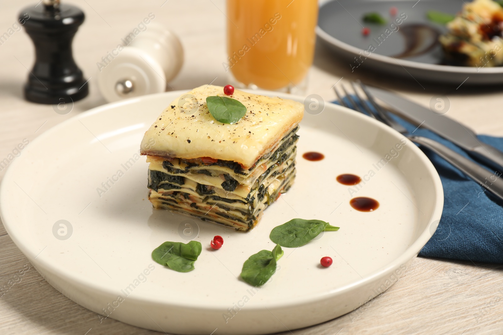 Photo of Piece of tasty spinach lasagna on wooden table, closeup