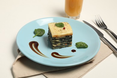 Photo of Piece of tasty spinach lasagna served on white table, closeup