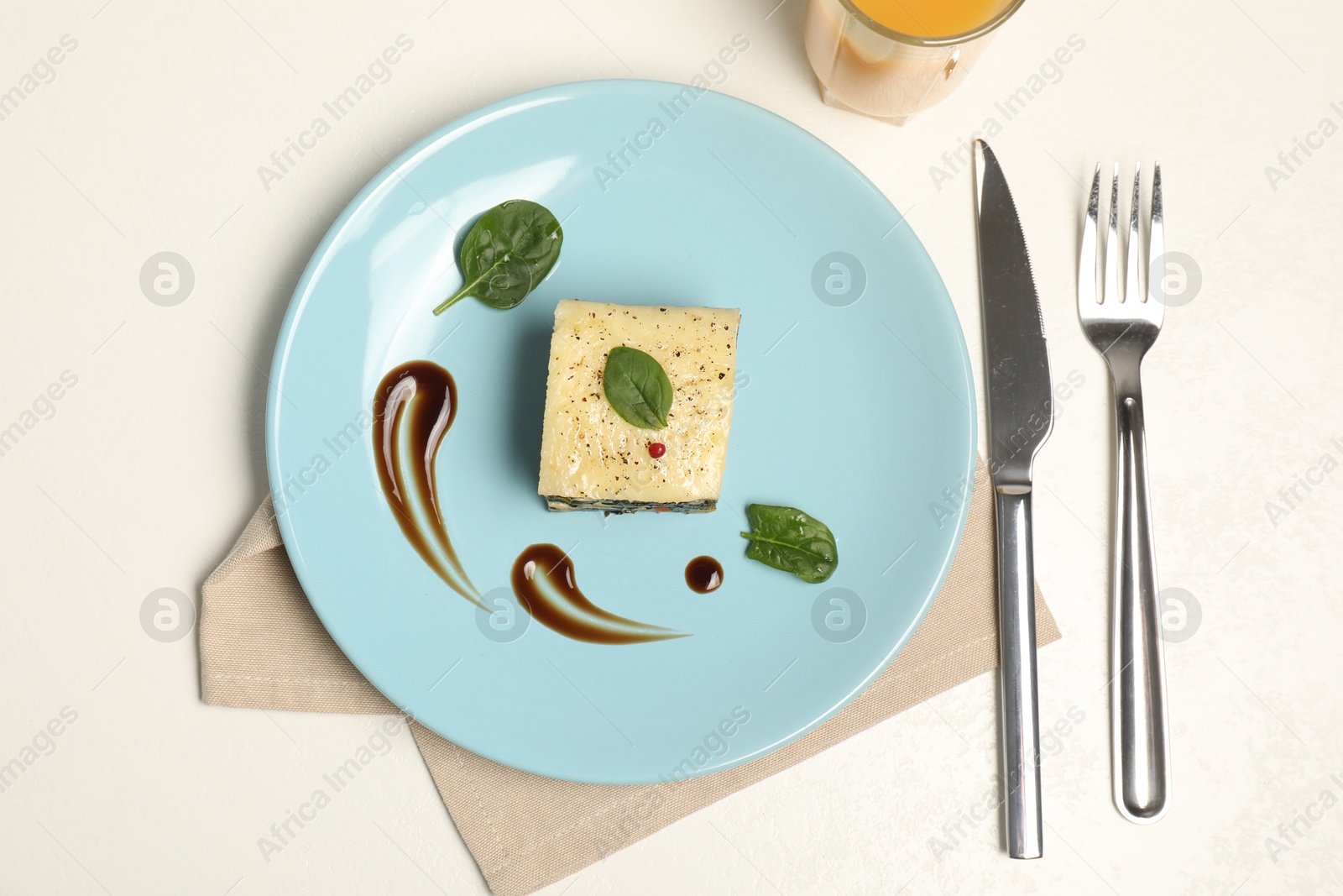 Photo of Piece of tasty spinach lasagna served on white table, flat lay