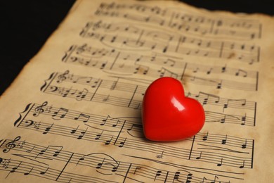 Photo of Heart figure and musical notes on black background, closeup