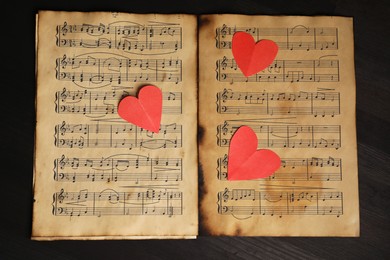 Photo of Paper hearts and musical notes on black background, top view