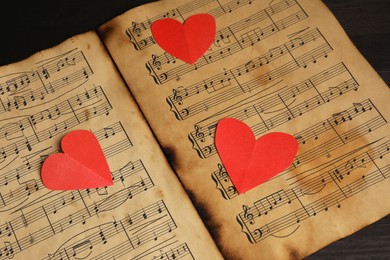 Photo of Paper hearts and musical notes on black background, closeup