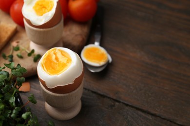 Photo of Soft boiled eggs on wooden table, closeup. Space for text