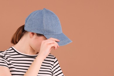 Photo of Woman in stylish baseball cap on beige background. Mockup for design