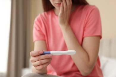 Photo of Woman with negative pregnancy test at home, closeup