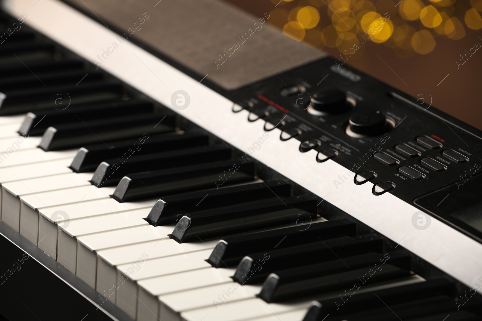 Photo of Piano against blurred lights, closeup. Bokeh effect