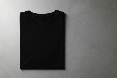 Photo of Blank black t-shirt on grey background, top view. Mockup for design