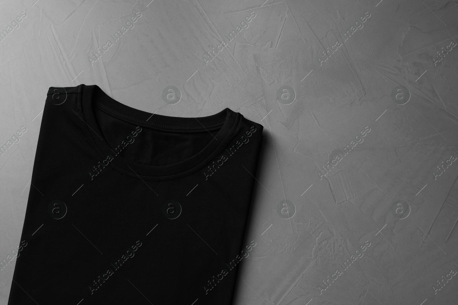 Photo of Blank black t-shirt on grey background, top view. Mockup for design