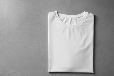 Photo of Blank white t-shirt on grey background, top view. Mockup for design