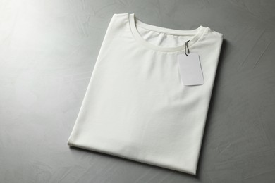 Photo of Blank white t-shirt on grey background, above view. Mockup for design