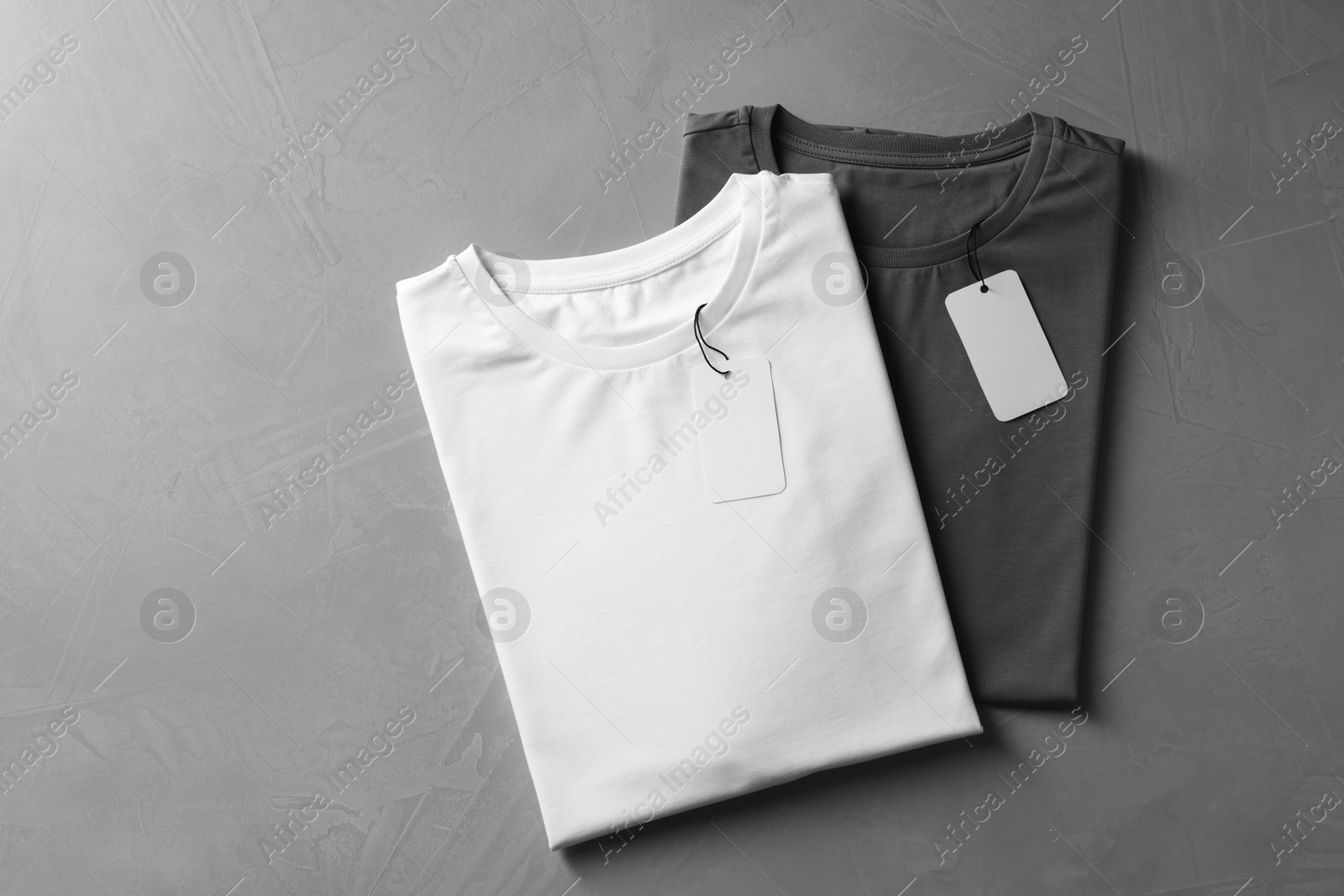 Photo of Different blank t-shirts on grey background, top view. Mockup for design