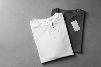 Photo of Different blank t-shirts on grey background, top view. Mockup for design