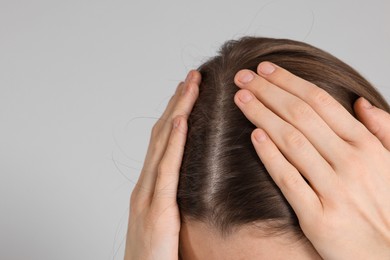 Photo of Girl with hair loss problem on grey background, closeup. Space for text