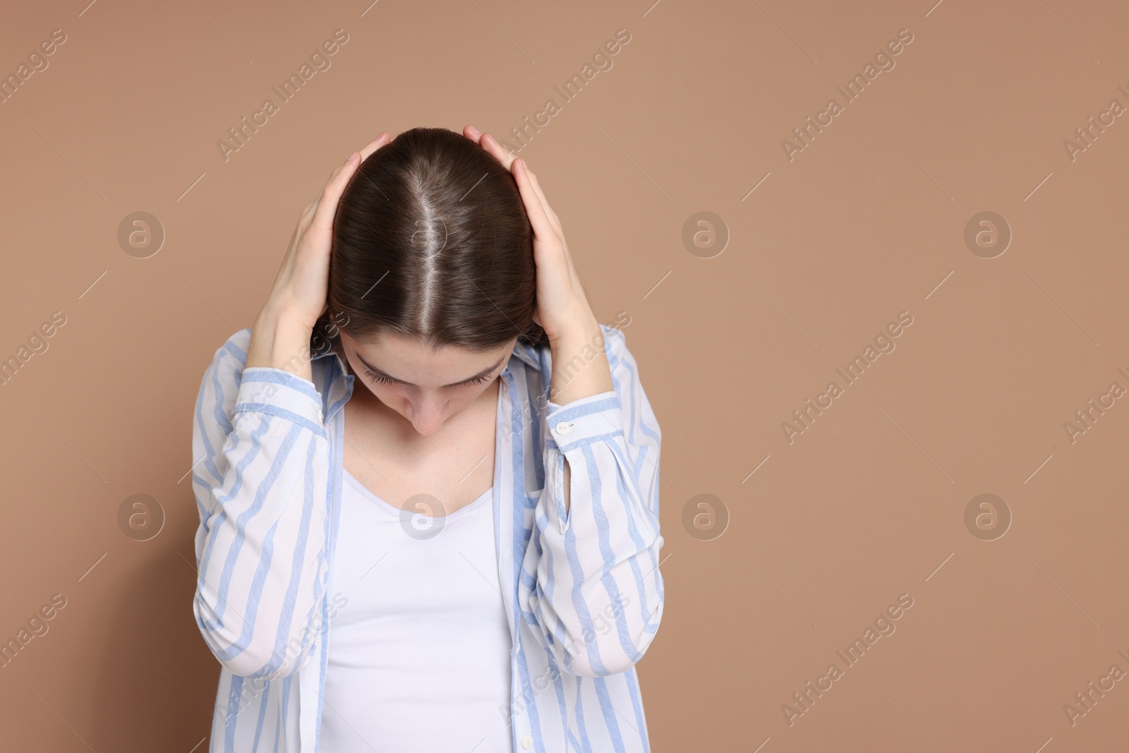 Photo of Girl with hair loss problem on dark beige background, space for text