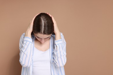 Photo of Girl with hair loss problem on dark beige background, space for text