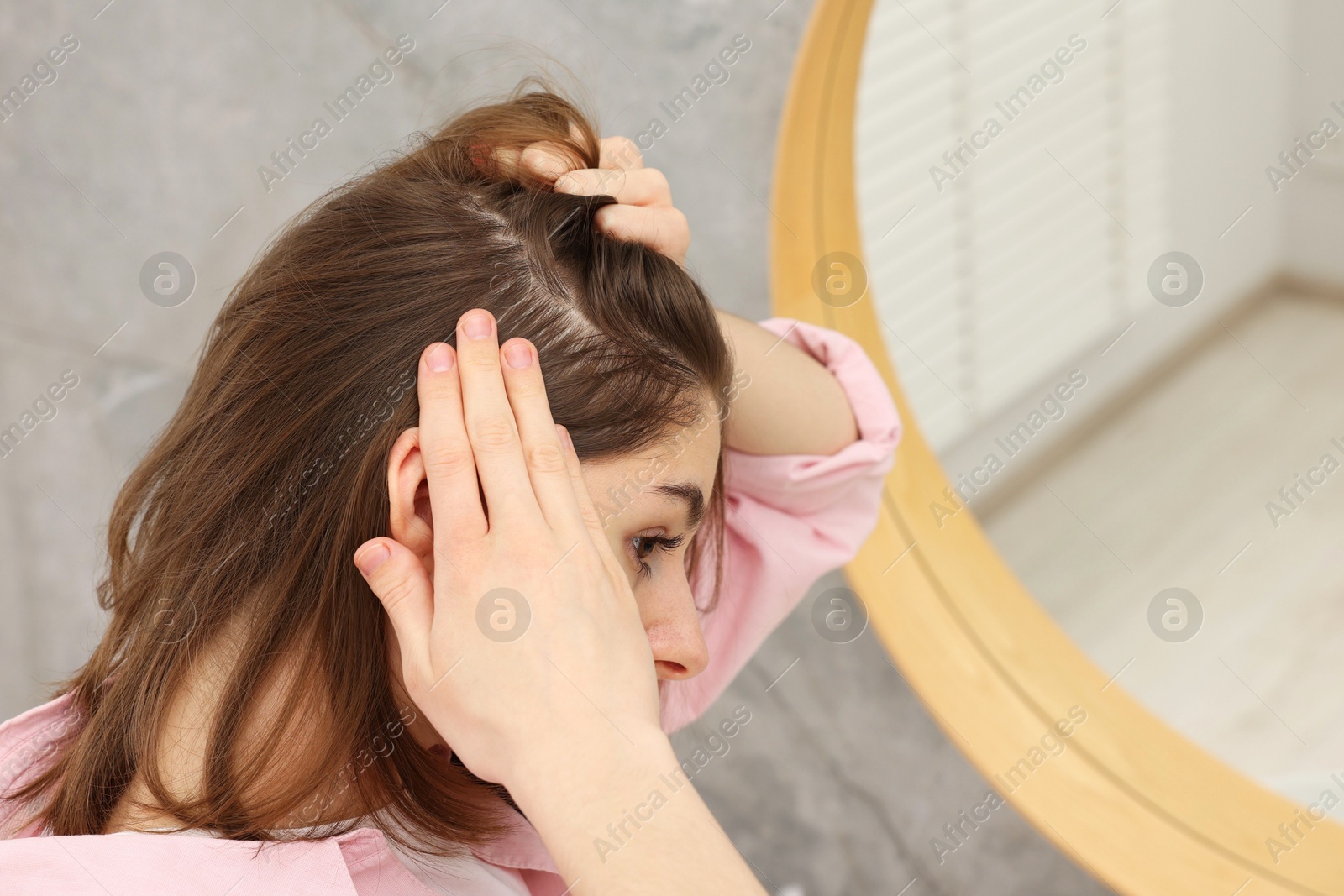 Photo of Girl with hair loss problem near mirror in bathroom, space for text