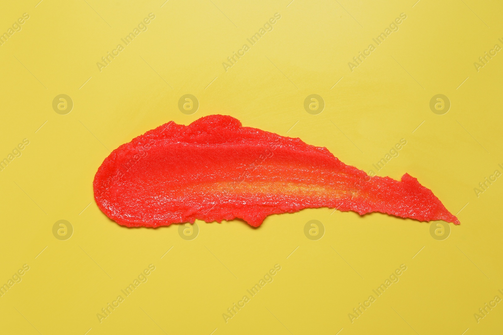 Photo of Sample of body scrub on yellow background, top view