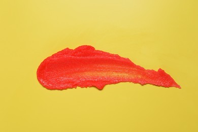 Photo of Sample of body scrub on yellow background, top view