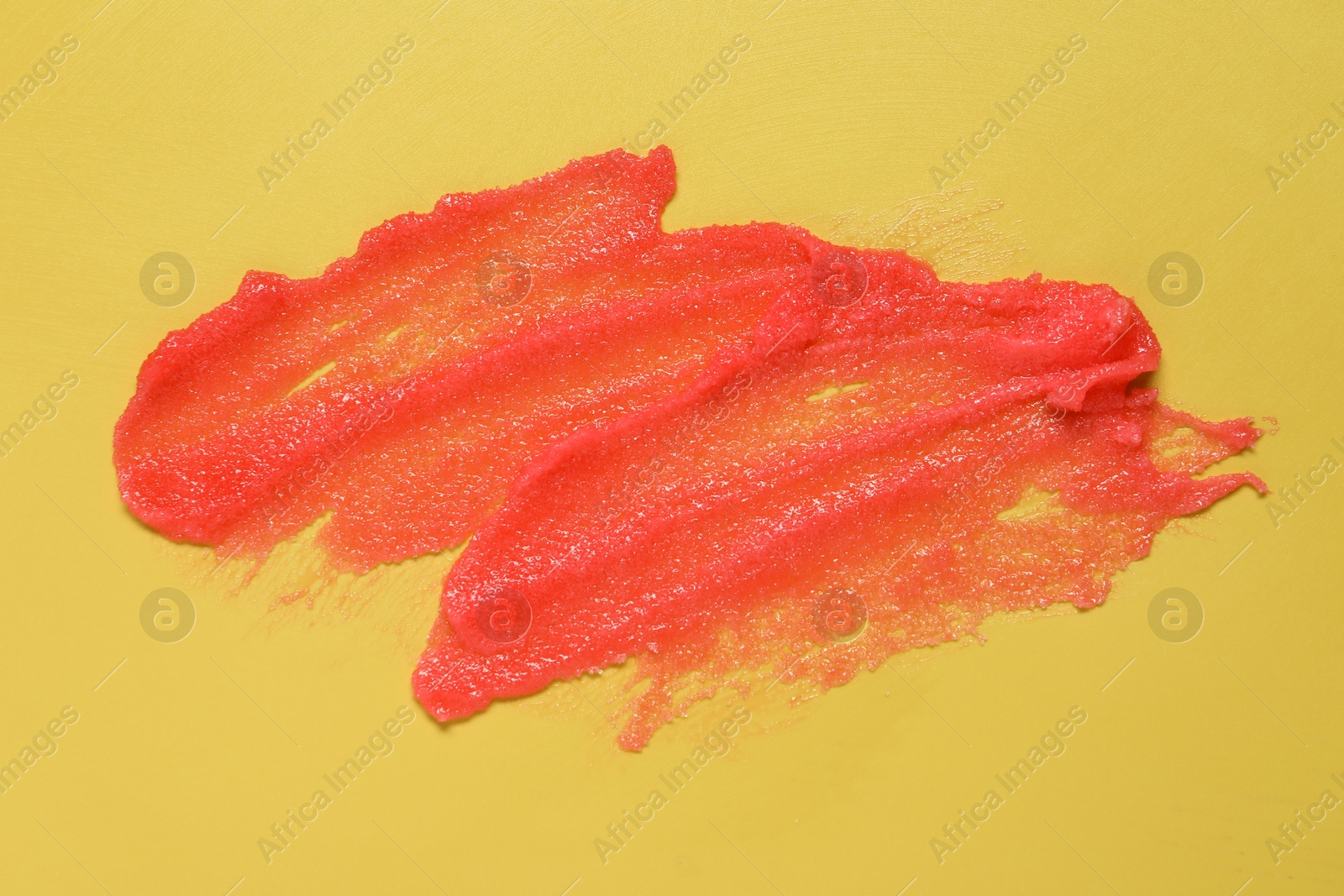 Photo of Sample of body scrub on yellow background, top view