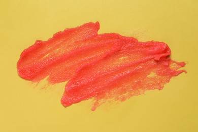 Photo of Sample of body scrub on yellow background, top view