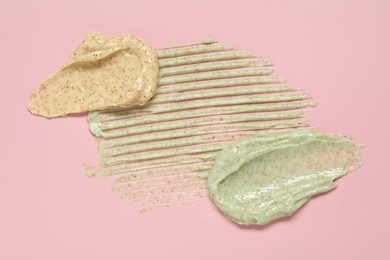 Photo of Samples of different body scrubs on pink background, top view