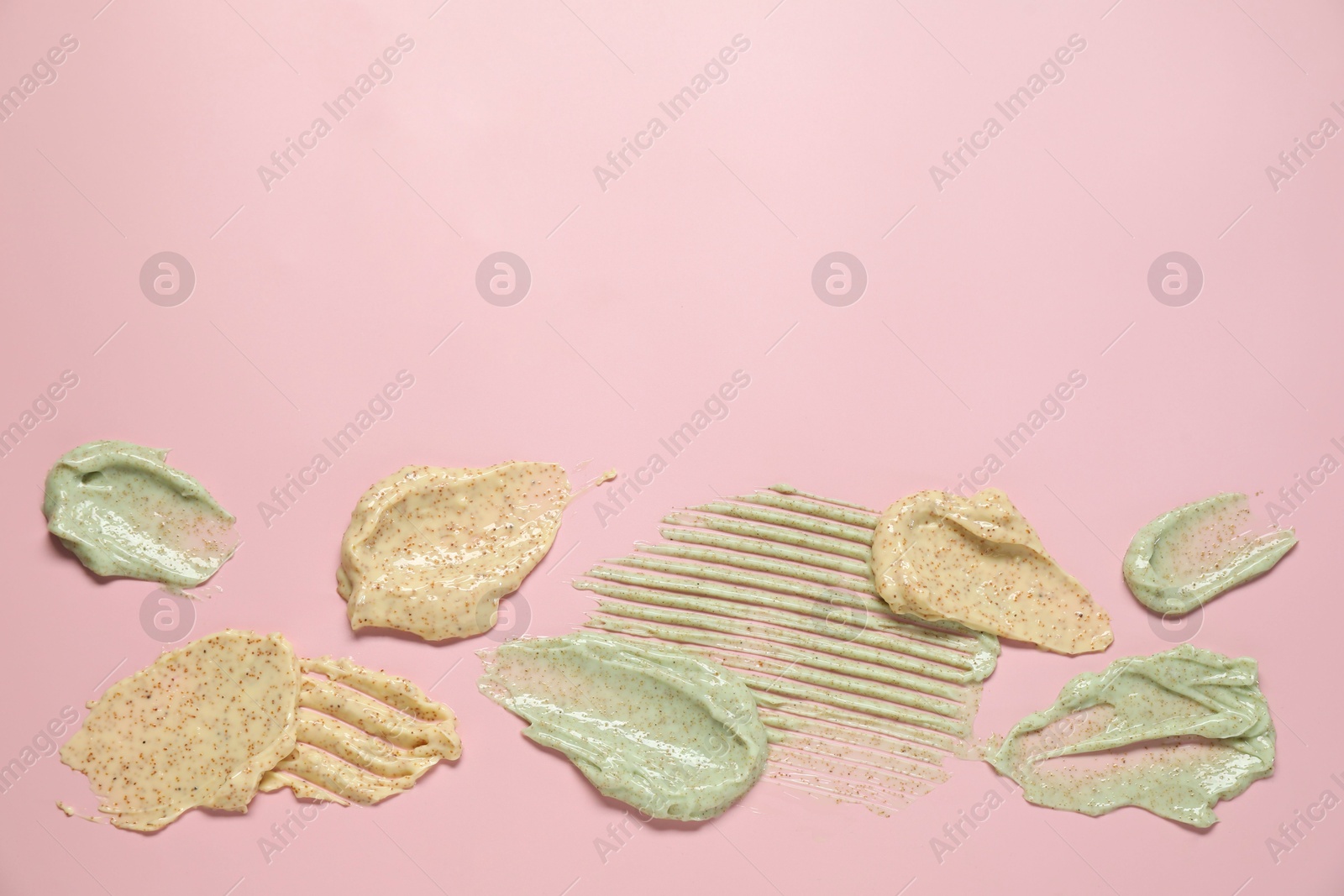 Photo of Samples of different body scrubs on pink background, top view. Space for text